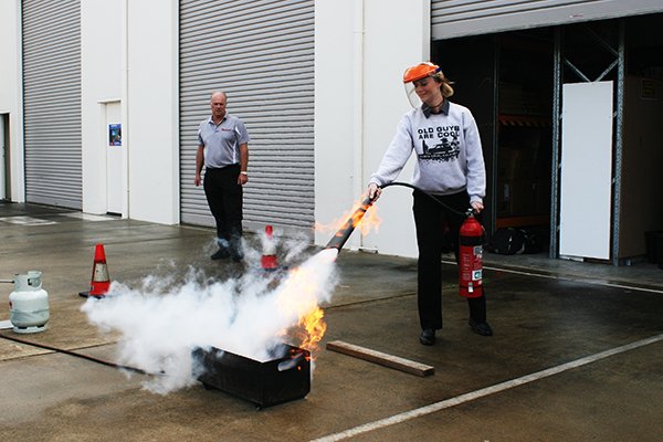 person using a fire extinguisher to put out a fire