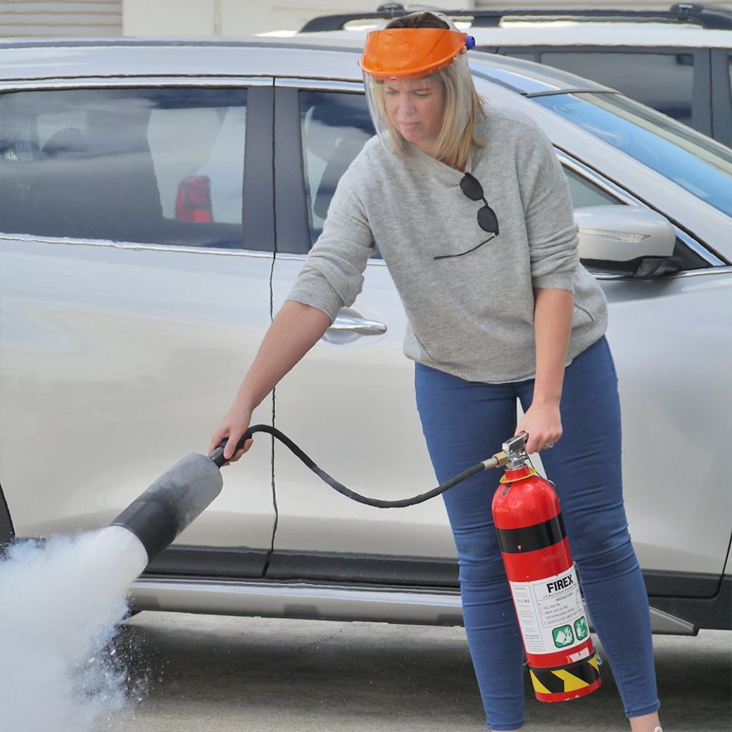 woman using a fire extinguisher